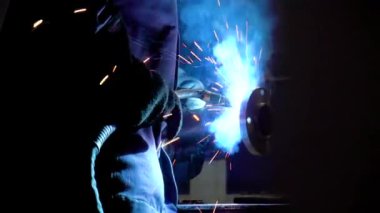 İşçi yarı otomatik kaynak makinesiyle çelik parçaları kaynaklıyor.