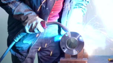 İşçi yarı otomatik kaynak makinesiyle çelik parçaları kaynaklıyor.