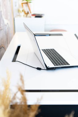 Rahat bir iş yeri. Üzerinde tahta masa ve dizüstü bilgisayar olan rahat bir iş yeri.