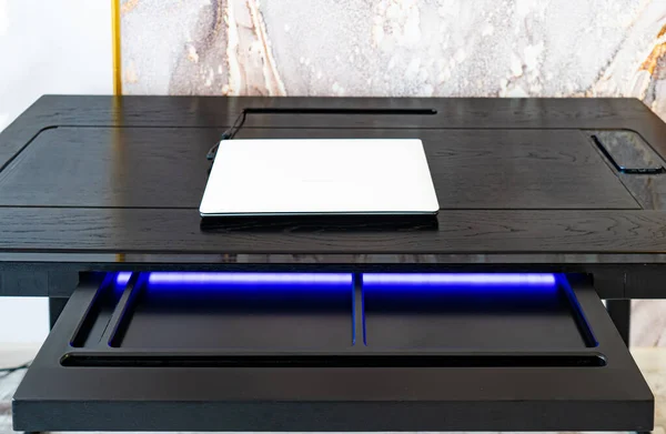 Top view of empty open wooden drawer office table with blue lightning. Modern office table with light