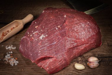 Ahşap arka planda baharatlı ve otlu biftek fileto.