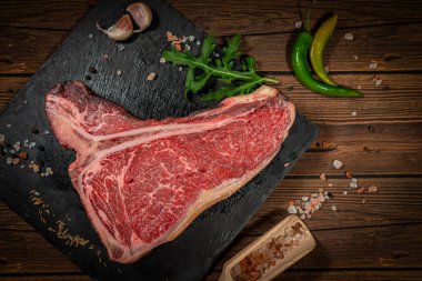 Baharatlı taze çiğ biftek ve ahşap arka plan manzaralı Himalaya tuzu. Sağlıklı ve organik gıda konsepti.