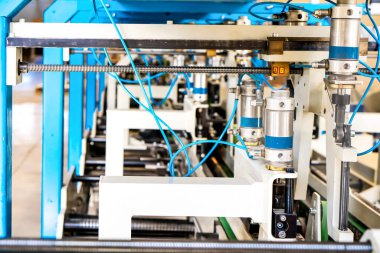 Kutulardaki ve bitmiş ürünlerdeki karton paketlerin montajı. Mekanizma üretim endüstrisi