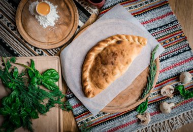 Tahta bir masada yumurta ve peynirli Gürcü lahanalı turta....