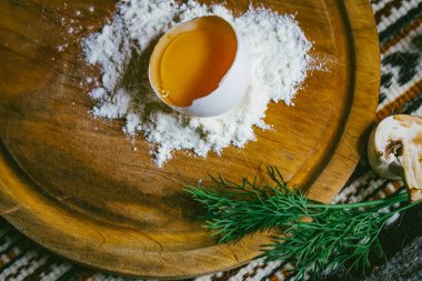 Mermer masanın üzerindeki un yığınının içinde taze yumurta var. Pizza ya da makarna için hamur. mesaj için yer. Üst Manzara. dikey resim.