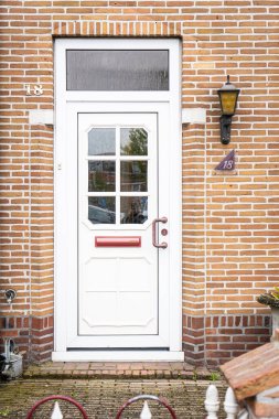 Facade of typical Dutch door house with brick walls, steps, front door windows. Doors on the street, Netherlands clipart