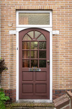 Tuğla duvarları, merdivenleri, ön pencereleri olan tipik bir Hollandalı kapı cephesi. Sokaktaki kapılar, Hollanda