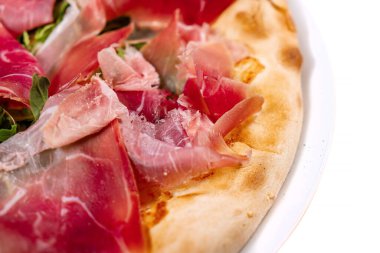 Jambonlu pizza, roka ve parmesan peyniri.