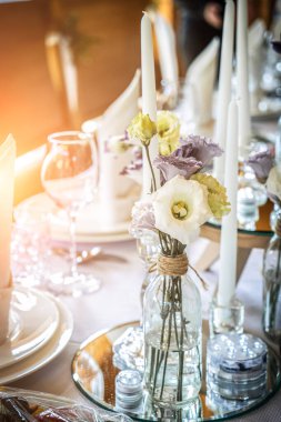 Çiçekler ve mumlarla düğün masası dekorasyonu. Zarif düğün masası misafirler için hazır. Düğün yemeği için şık bir masa.