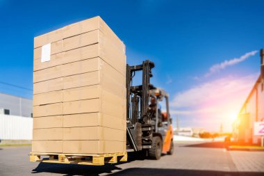 Forklift aracı deponun dışındaki lojistik alanda malları manipüle ediyor..
