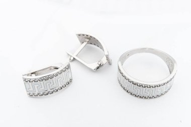 Gümüş mücevher seti ve taştan beyaz arka planı olan gümüş küpeler. Gümüş mücevher koleksiyonu