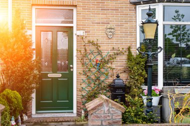 Facade of typical Dutch door house with brick walls, steps, front door windows. Doors on the street, Netherlands clipart