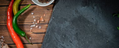 biberiye ve baharatlı rustik kesim tahtası, koyu kırsal ahşap arka plan, üst görünüm, metin