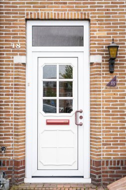 Facade of typical Dutch door house with brick walls, steps, front door windows. Doors on the street, Netherlands clipart