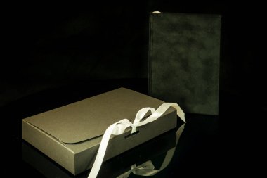 Erkekler için en iyi hediye. Erkek hediye konsepti. Siyah arka planda siyah hediye kutusu olan siyah defter. Uzay metnini kopyala Sevgililer günü, düğün, doğum günü ve özel bir hediye konsepti. Metin için alanı kopyala.
