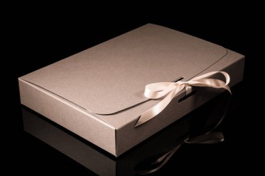 Erkek hediye konsepti. Arkaplanda lüks bir fiyonk olan hediye kutusu. Kopyalama alanı ile yatay.