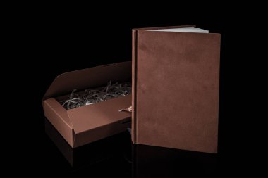 Erkekler için en iyi hediye. Erkek hediye konsepti. Siyah arka planda kırmızı hediye kutusu olan kırmızı defter. Uzayı kopyala Sevgililer günü, düğün, doğum günü ve özel bir hediye konsepti. Metin için alanı kopyala.