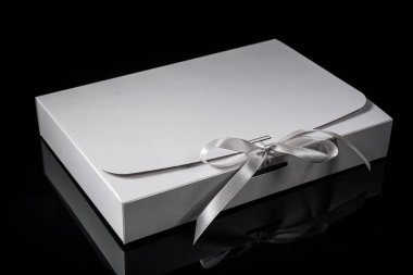 Erkek hediye konsepti. Arkaplanda lüks bir fiyonk olan hediye kutusu. Kopyalama alanı ile yatay.