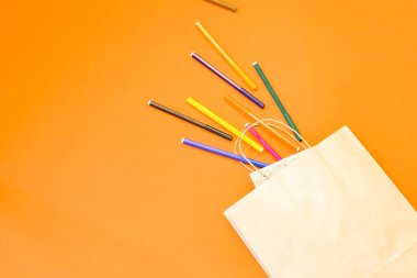 Renkli arka planda en üstteki kahverengi kağıt alışveriş torbası, boş kahverengi kağıt alışveriş torbası ve fotokopi alanı. Düz yatıyordu.