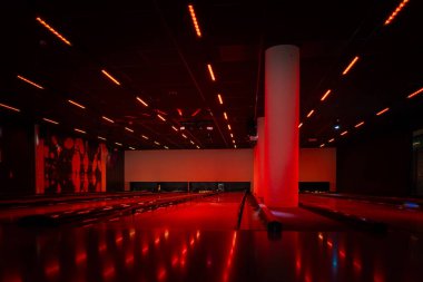 Aydınlatılmış bir bowling salonu. Işıklı, modern, karanlık bir bowling şeridi. Bowling için aydınlık sokak