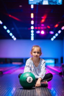 Mutlu genç kız bowling oynarken eğleniyor ve tezahürat yapıyor.