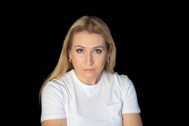 Beyaz arka planda duran genç sarışın kadın şüpheci ve gergin, yüzünde çapraz kollu tasvip etmeyen ifade. negatif kişi.