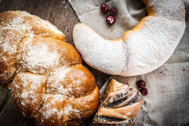 Ahşap masa zemininde taze ekmek ve çörekler var.