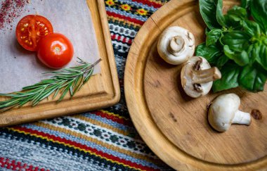 Pizza ya da makarna için yemek malzemeleri. Taze kiraz domatesleri, mantarlar, fesleğen yaprakları, zeytinyağı. Kapatın. Uzayı kopyala Boş alan metni