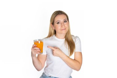 Portakal suyu bardaklı genç sarışın kadın elinde meyve suyu tutan beyaz bir arka plan izole etti. Beyaz tişörtlü bir kadın portresi ve bir bardak içki. Model.