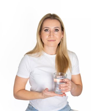 Beyaz elbiseler giyen genç bir kadın cam kaplamalı temiz, saf, durgun bir su içerek açık yeşil arka planda izole edilmiş bir jest yapar. Düzgün beslenme sağlıklı fast food seçimi konsepti