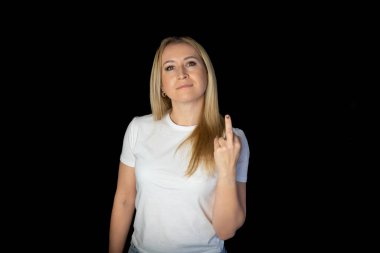 blonde cheeky young woman model show middle finger, fuck you off sign. Bad expression, provocation and rude attitude.
