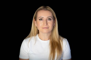 Beyaz tişörtlü, güzel saçlı, sarışın bir kadının portresi. Güzel bir kadın stüdyoda kameraya bakıyor..