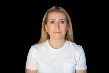 Beyaz tişörtlü, güzel saçlı, sarışın bir kadının portresi. Güzel bir kadın stüdyoda kameraya bakıyor..