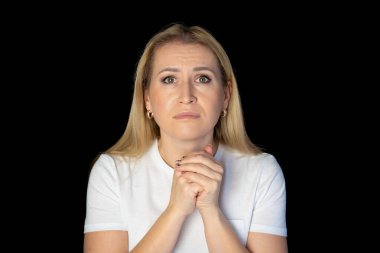 Beyaz tişörtlü, güzel saçlı, sarışın bir kadının portresi. Güzel bir kadın stüdyoda kameraya bakıyor..