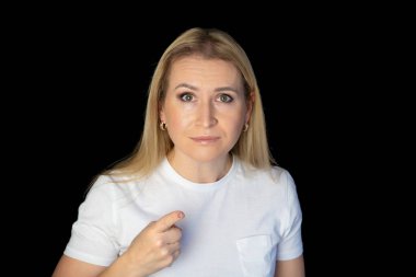 Beyaz arka planda duran genç sarışın kadın şüpheci ve gergin, yüzünde çapraz kollu tasvip etmeyen ifade. negatif kişi.