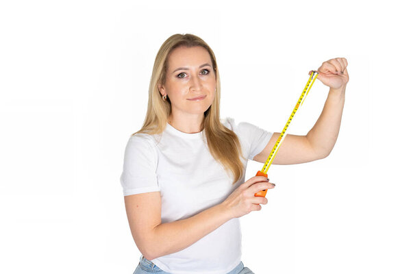 Белая блондинка держит измерительную ленту. Включить измерительную ленту в женской руке. Концепция здания