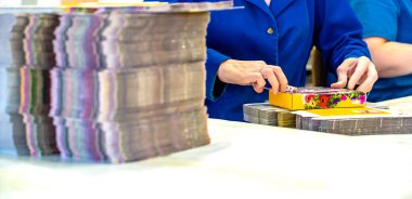 Depoda sevkiyat için kutuları toplayan genç bayan işçi.