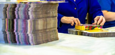 Depoda sevkiyat için kutuları toplayan genç bayan işçi.