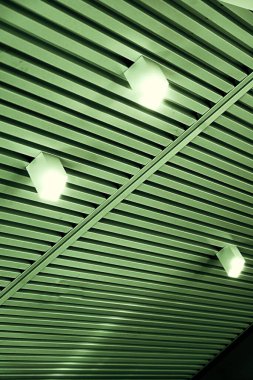 Modern bir depoda parlak ışıkları olan bir tavan, alışveriş merkezi binası, ofis veya diğer ticari gayrimenkul eşyaları. Tavanın altındaki raylarda LED ışıkları