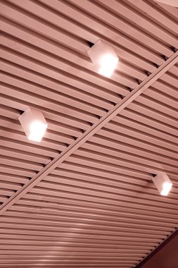 Modern bir depoda parlak ışıkları olan bir tavan, alışveriş merkezi binası, ofis veya diğer ticari gayrimenkul eşyaları. Tavanın altındaki raylarda LED ışıkları