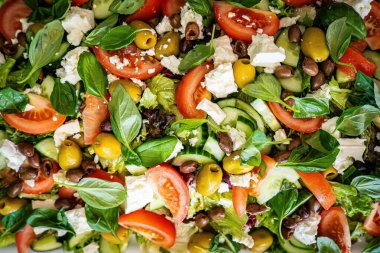 Taze domatesli sağlıklı sebze salatası, yeşil yapraklı karışım ve sebze. Koyu arkaplanda üst görünüm. Diyet menüsü