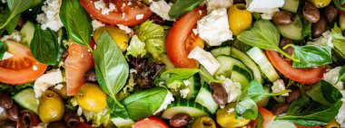 Taze domatesli sağlıklı sebze salatası, yeşil yapraklı karışım ve sebze. Koyu arkaplanda üst görünüm. Diyet menüsü