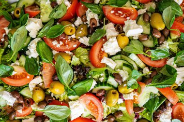 Taze domatesli sağlıklı sebze salatası, yeşil yapraklı karışım ve sebze. Koyu arkaplanda üst görünüm. Diyet menüsü