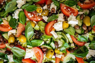 Taze domatesli sağlıklı sebze salatası, yeşil yapraklı karışım ve sebze. Koyu arkaplanda üst görünüm. Diyet menüsü