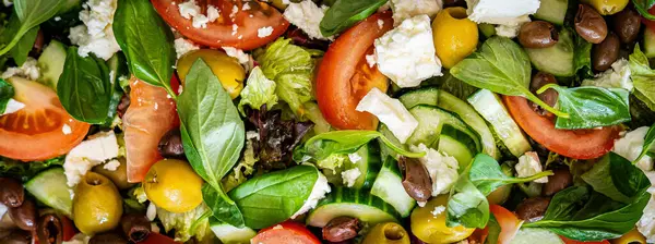 Taze domatesli sağlıklı sebze salatası, yeşil yapraklı karışım ve sebze. Koyu arkaplanda üst görünüm. Diyet menüsü