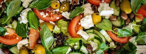 Taze domatesli sağlıklı sebze salatası, yeşil yapraklı karışım ve sebze. Koyu arkaplanda üst görünüm. Diyet menüsü