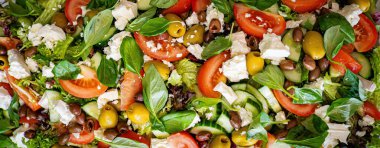 Taze domatesli sağlıklı sebze salatası, yeşil yapraklı karışım ve sebze. Koyu arkaplanda üst görünüm. Diyet menüsü