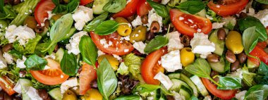 Taze domatesli sağlıklı sebze salatası, yeşil yapraklı karışım ve sebze. Koyu arkaplanda üst görünüm. Diyet menüsü