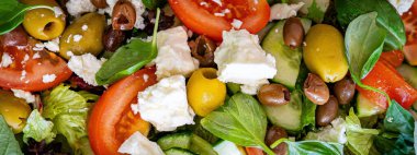 Taze domatesli sağlıklı sebze salatası, yeşil yapraklı karışım ve sebze. Koyu arkaplanda üst görünüm. Diyet menüsü