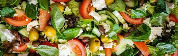 Taze domatesli sağlıklı sebze salatası, yeşil yapraklı karışım ve sebze. Koyu arkaplanda üst görünüm. Diyet menüsü